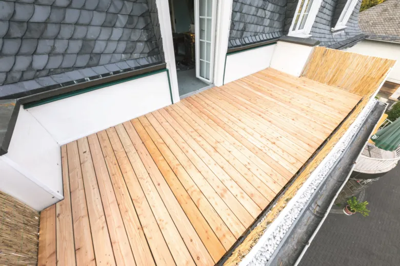 Nová dřevěná podlaha na zatepleném balkónu s viditelnou izolací.