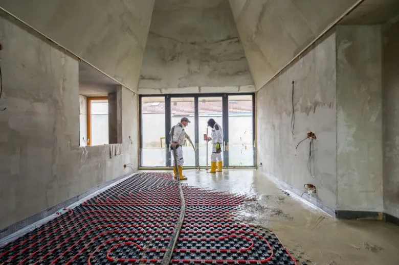 Instalace podlahového vytápění s výškou betonu v budově.