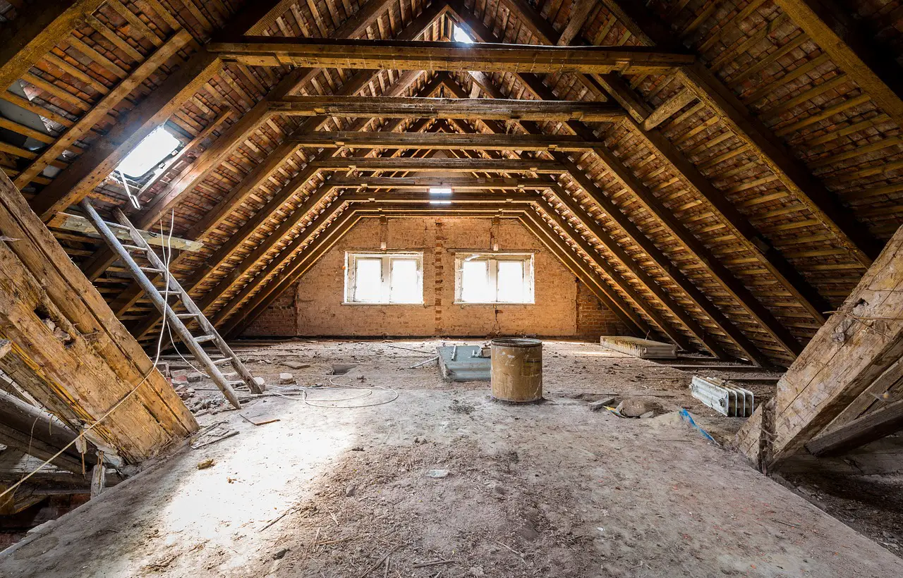 Prázdný podkroví s dřevěnou konstrukcí stropu během rekonstrukce.