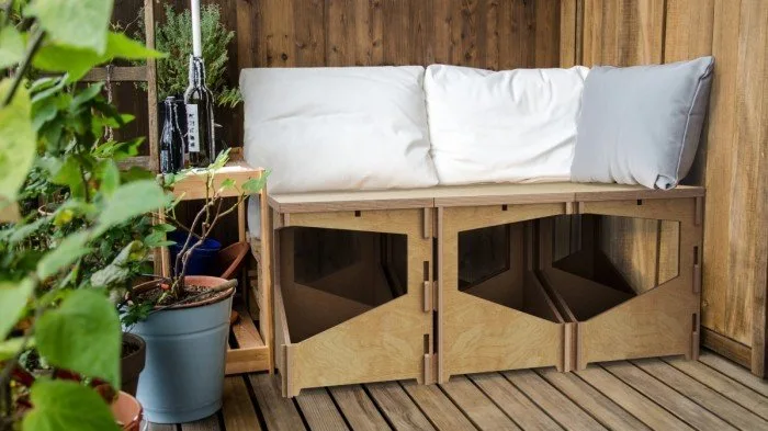 Dřevěná lavička s úložným prostorem na panelákovém balkóně.