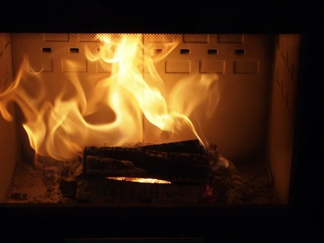 Hořící dřevo v krbu s jasnými plameny