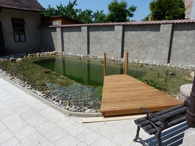 Venec pro koupání s dřevěným přístavkem v zahradním prostředí.