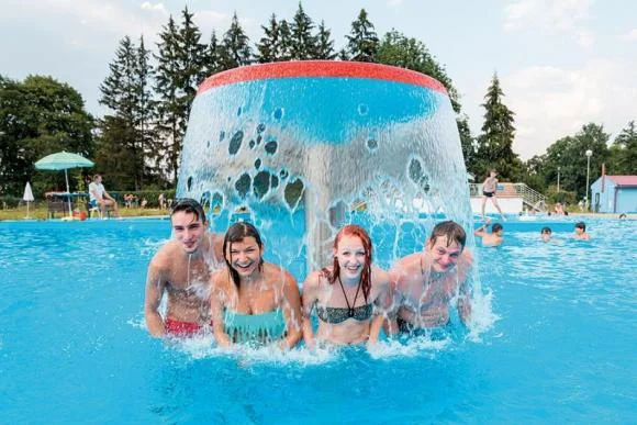People in outdoor pool splash feature