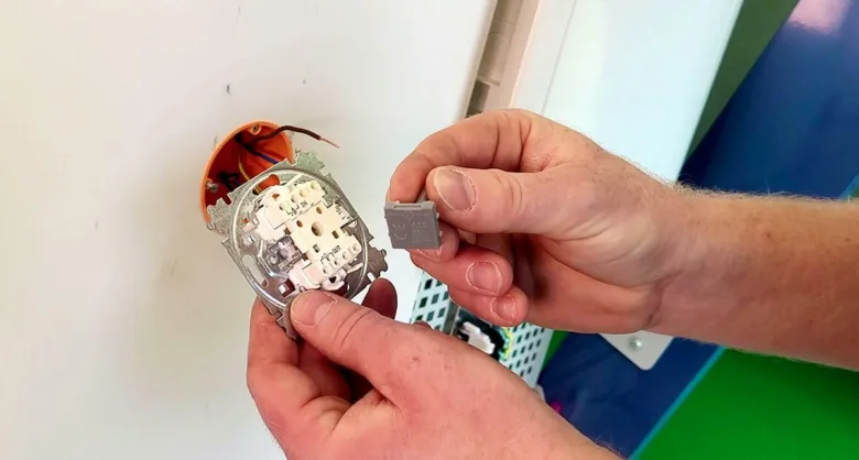 Ruční montáž vypínače s viditelnými vodiči v elektroinstalaci