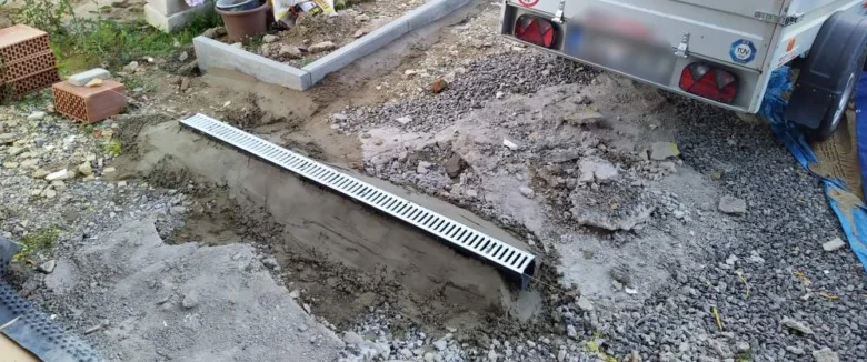 Stavba vjezdu do garáže s kamínky a betonovými formami.