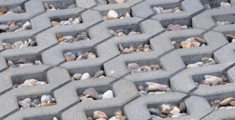 Betonové zatravňovací kostky s kamínky na chodníku.