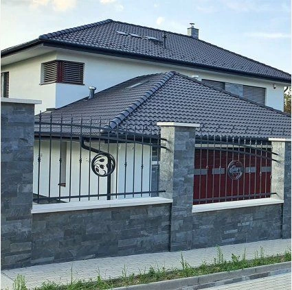 Moderní dům s fasádou obloženou šedým kamenným kachlem.