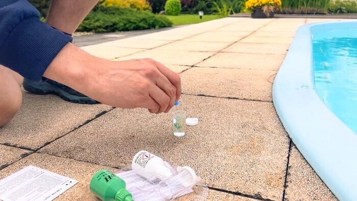 Testování kvality vody v bazénu pomocí chemických prostředků.