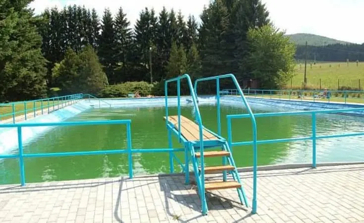 Outdoor swimming pool with stairs and railings