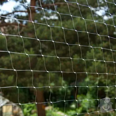 Bílá ochranná síť pro balkony s venkovním pozadím.