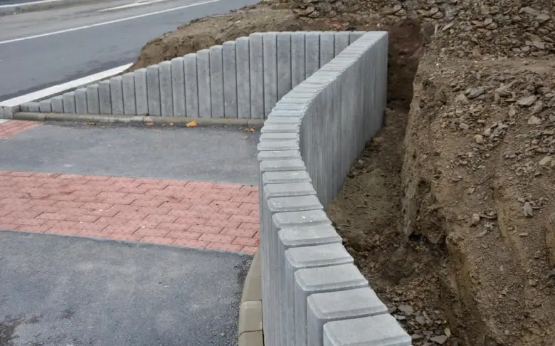 Ukázka svahových tvárnici při montáži na silničním náspu vedle chodníku.