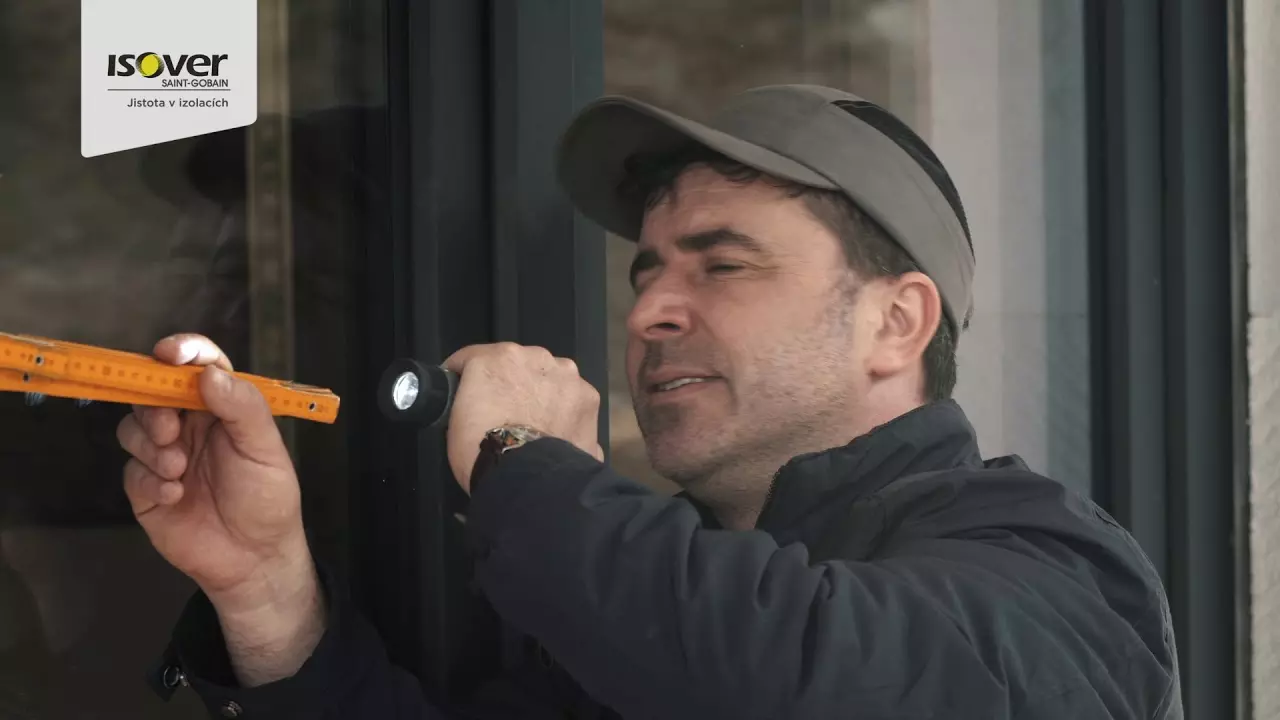 Muž kontroluje kotvicí systém pro styropor na fasádě