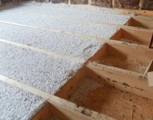 Sypaný EPS granulát v dřevěném bednění před tlačením.
