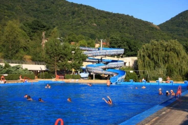 Venkovní bazén s vodními skluzavkami v termálním koupališti