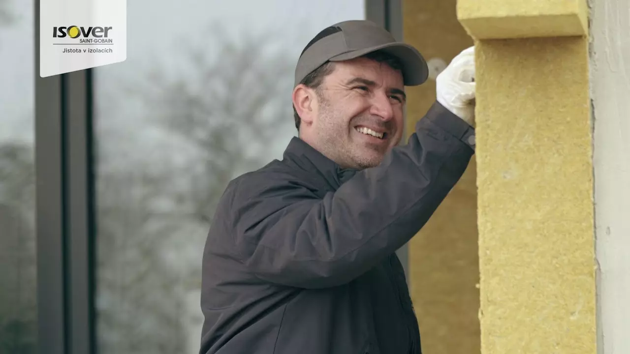 Muž instaluje minerální vlnu na fasádu při zateplování domu.