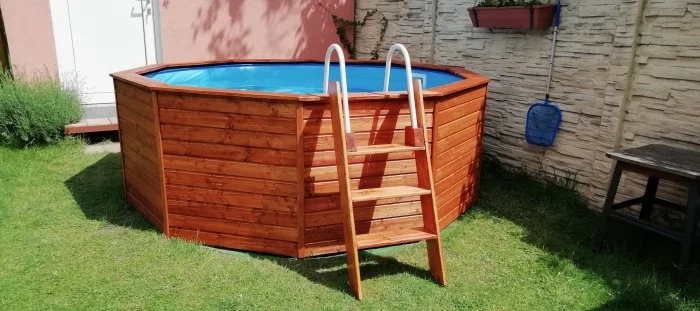 Nahrazený bazén s dřevěným obložením a schodištěm.
