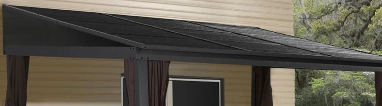 Pergola s tmavou krytinovou střechou pro zahradní stínění.