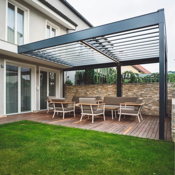 Moderní kovová pergola s sedací soupravou u domu.