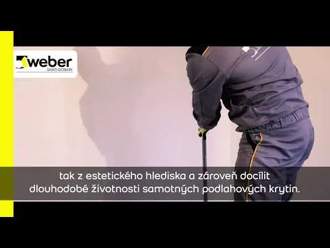 Pracovník nanáší samonivelační stěrku na podlahu.