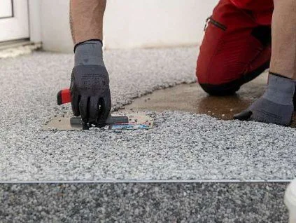 Montáž epoxidové podlahy: stěrka se nanáší na betonovou plochu.
