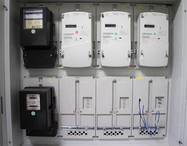 Vnitřní pohled na elektroměrový rozvaděč s měry a přepínači.