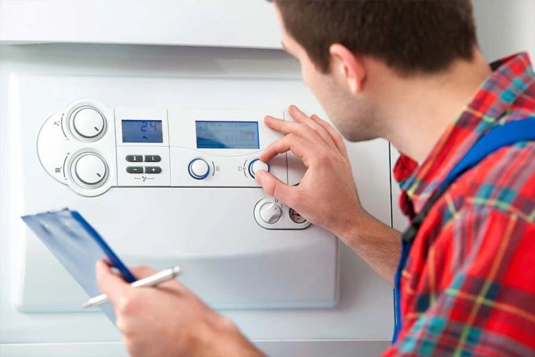 Technician adjusting boiler controls