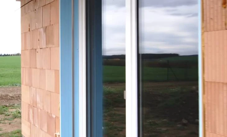 Detailní pohled na ostění okna s izolačním materiálem v budování.