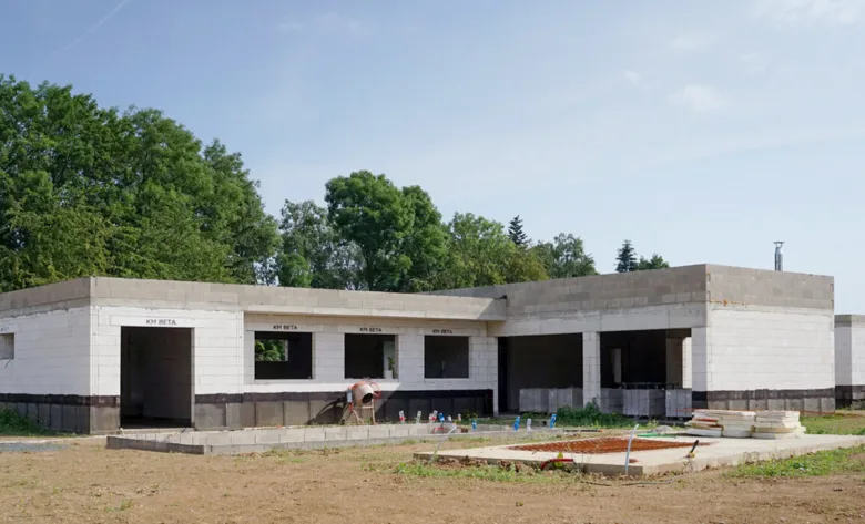 Stavba rodinného domu v hrubé stavbě na pozemku.