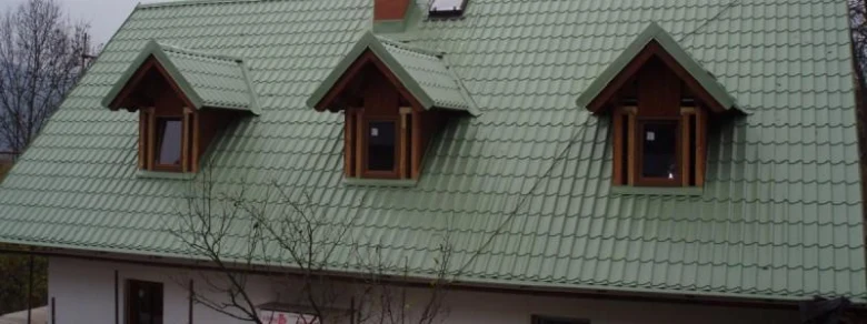 Zelená střecha s mansardovými okny po rekonstrukci.