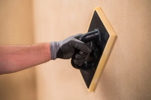 Plastering wall with trowel
