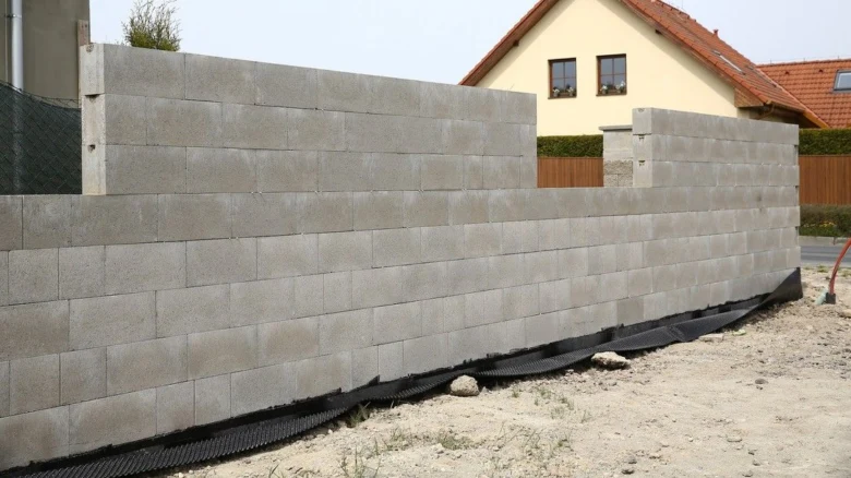 Stěna z betonových bloků s odvodněním pro české stavební články.