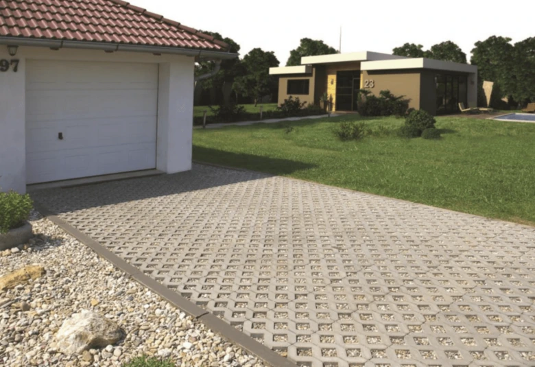 Zatravňovací dlažba s betonovými kostky na parkovišti u garáže.
