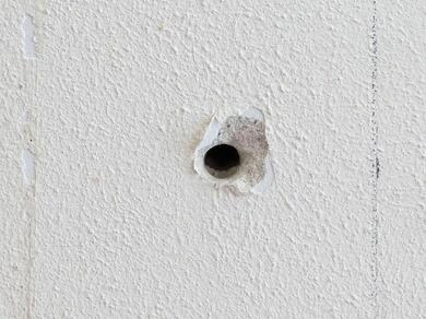 Díra ve zdi vyžadující použití tmelu na opravu.