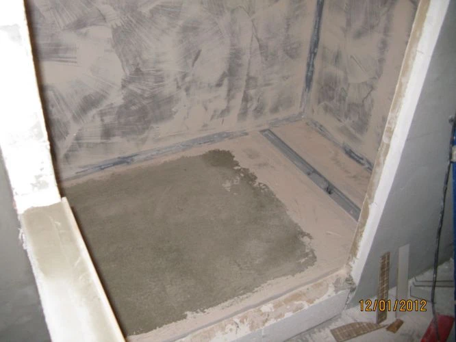 Sprchový kout bez vaničky v průběhu instalace s viditelnou hydroizolací.