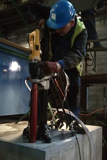 Pracovník vrtá jádro do betonu pomocí speciálního vrtače