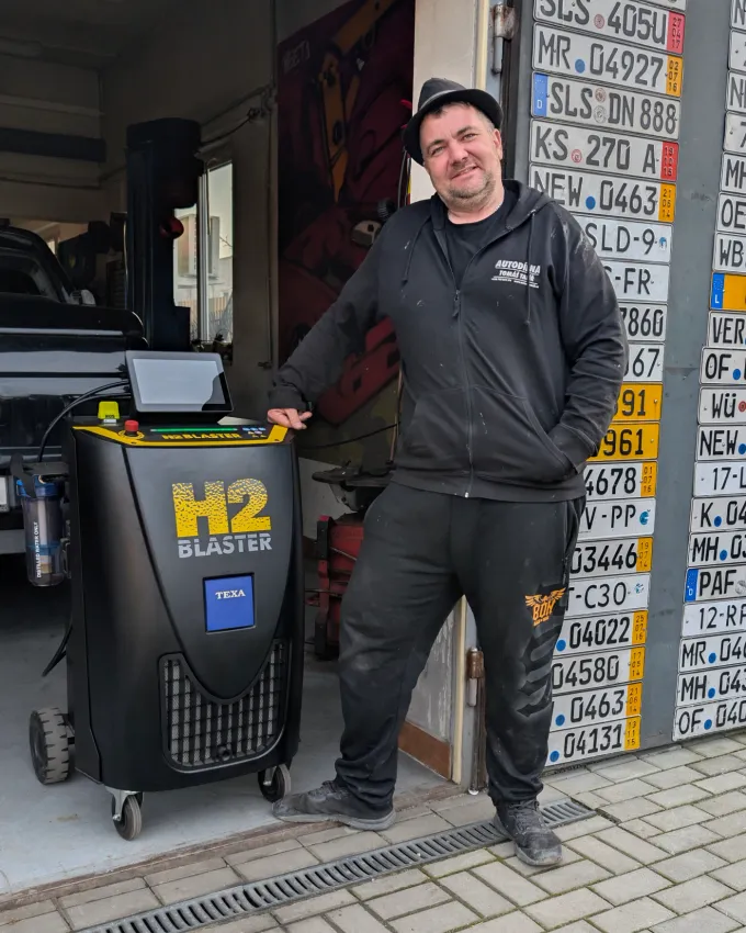 Muž s generátorem vodíku v servisu klimatizací.
