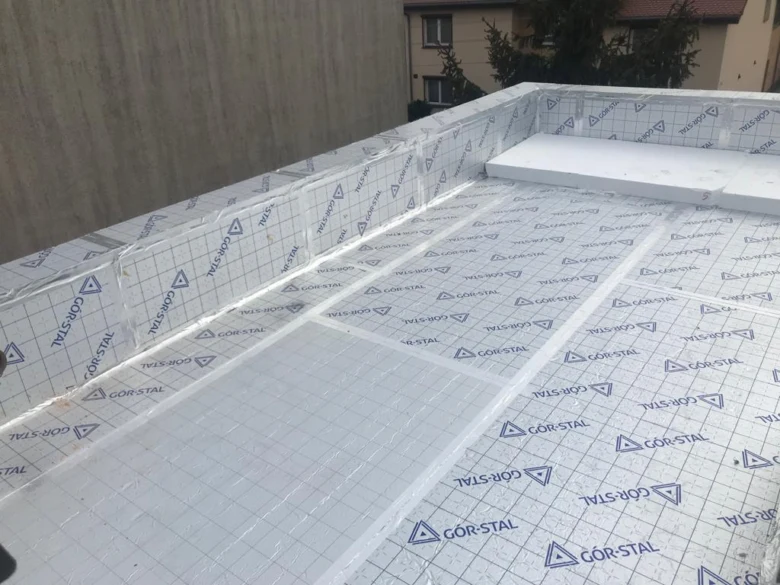 Montáž izolačních desek na rovnou střechu s ochrannou fólií.