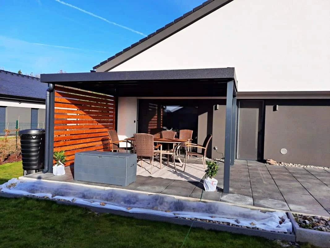Dřevěná pergola s venkovním posezením a zahradou.