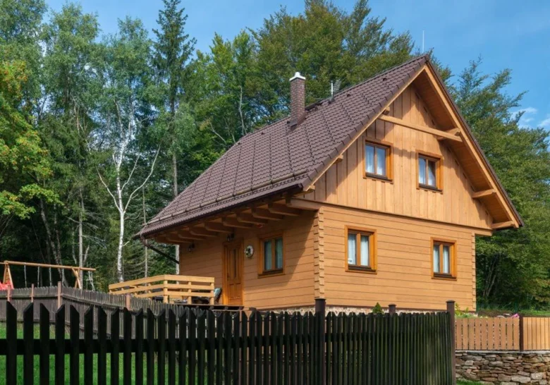Moderní dřevěný dům s plotem v přírodě