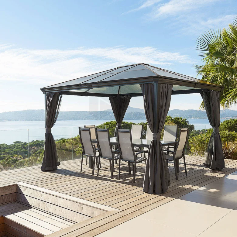 Venkovní pergola s jídelním setem na dřevěné terase u vody.