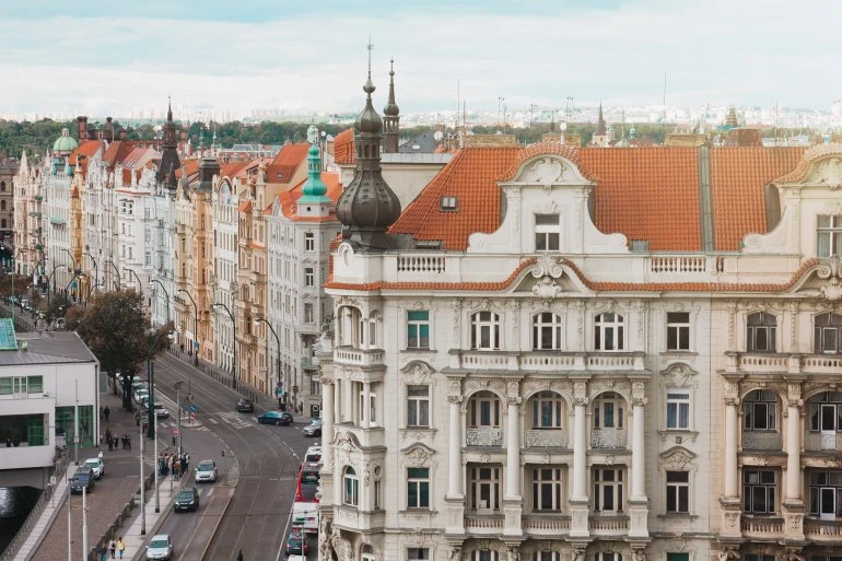 Historické budovy s bílými fasádami kombinovanými s červenou střechou.