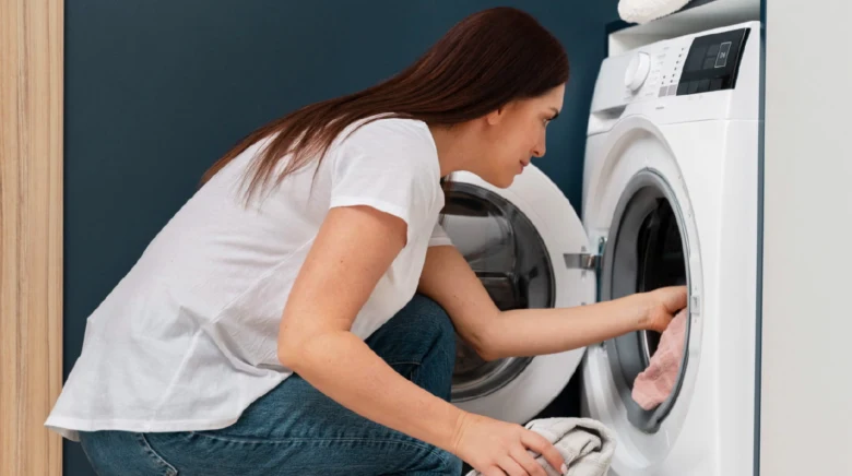Žena ukládá prádo do pračky, neukazuje sifon ani výšku instalace.