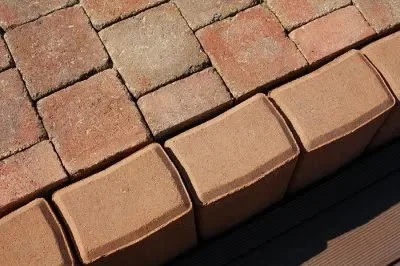 Červené tvárnice uspořádané ve svahu pro stavbu.