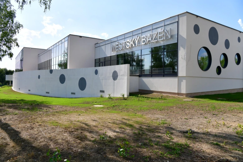 Moderní krytý městský bazén v Karviné s kruhovými okny.