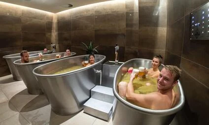 Muži v kovových vanách s pitím ve wellness centru.