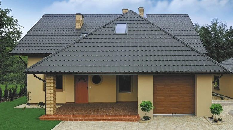 Moderní dům s plechovou střešní krytinou v šedé barvě.