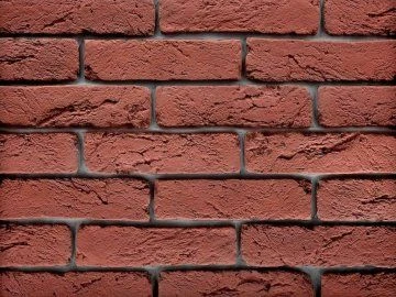 Červená cihlová fasáda s texturou obkladových pásků.
