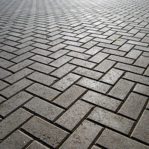 Světlá dlažba z betonu v kachlovém vzoru na chodníku.