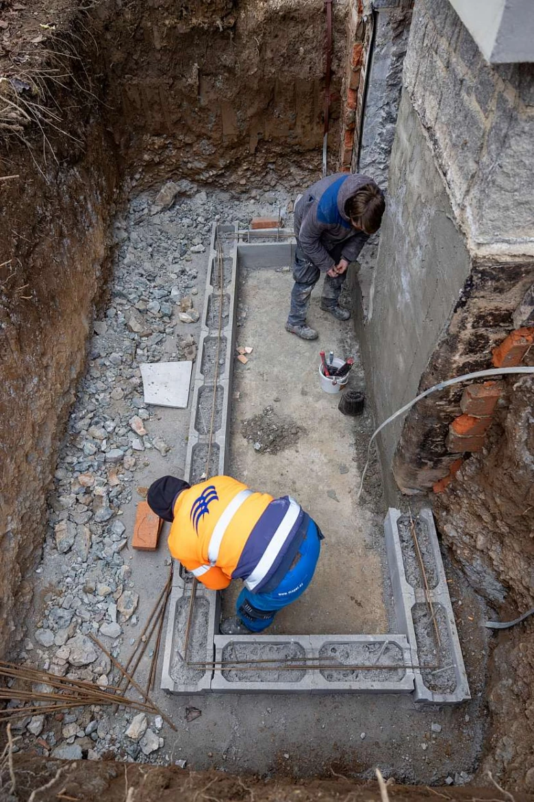 Stavebníci budují betonový rám pro vstup do sklepa.
