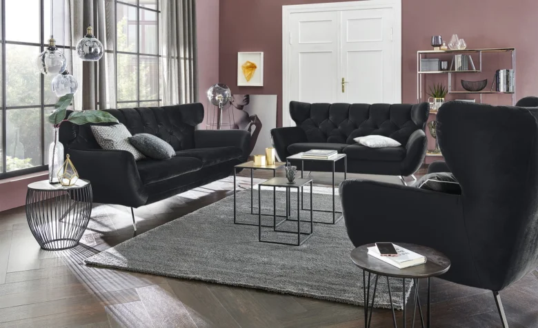 Moderní obývací pokoj s černými pohovkami a interiérovým designem.